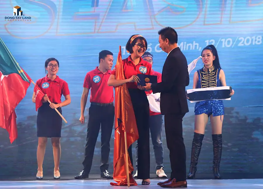 Ông Nguyễn Hữu Việt (Giám đốc Kinh doanh BĐS Nghỉ dưỡng - Tập đoàn Vingroup) trao phần thưởng giải nhất cho chị Hoàng Kim Ngọc (TPKD sàn giao dịch Đông Tây Land 5)